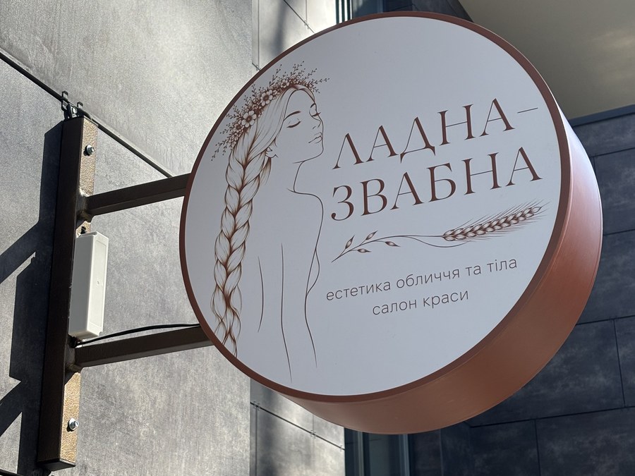 Кругла вивіска «Ладна-Звабна» біля входу до салону